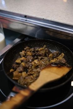 A delectable dish of fried beef and vegetables in a non-stick pan, ready to serve.